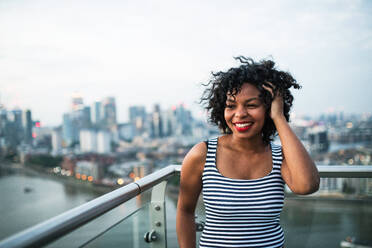 Porträt einer schwarzen Geschäftsfrau vor dem Panorama einer Londoner Dachterrasse, Raum kopieren. - HPIF30275