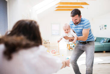 Portrait of young family with a baby boy at home, having fun. - HPIF30294