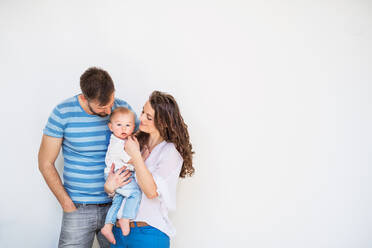 Porträt einer jungen Familie mit einem kleinen Jungen, der zu Hause steht und für das Foto posiert, Kopierraum. - HPIF30301