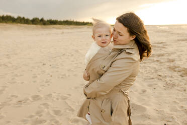 Smiling mother hugging son at beach - VIVF00954