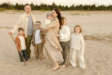 Glückliche Familie am Strand stehend - VIVF00990