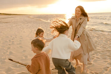 Happy mother having fun with children at sunset - VIVF01014