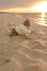 Cute baby boy playing in sand at beach - VIVF01024