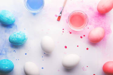 Painted eggs, paint and brush flat lay on a white background. Easter and spring composition. Studio shot. Copy space. - HPIF30445