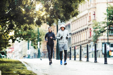 Ein fittes, sportliches Paar läuft im Freien auf den Straßen von Prag, Tschechische Republik. - HPIF30484