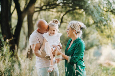 Junge Familie mit einer kleinen Tochter, die in der sonnigen Sommernatur Zeit miteinander verbringen. - HPIF30558