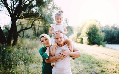 Young family with a small daughter spending time together in sunny summer nature. - HPIF30571