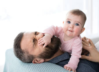 Reifer Vater spielt mit glücklichem Baby Tochter sitzt drinnen, Spaß haben. - HPIF30597