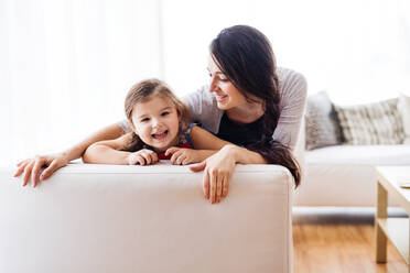 Young mother with a small girl at home, playing. - HPIF30605