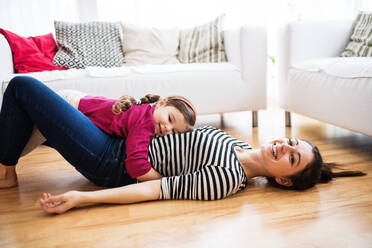 Young mother with a small girl at home, playing. - HPIF30618