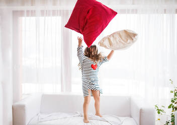 A cute small happy girl in striped T-shirt at home having fun. - HPIF30634