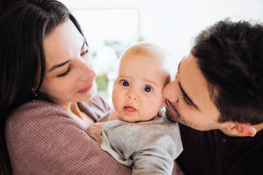 Nahaufnahme eines glücklichen jungen Paares mit einem Baby in einem Haus. - HPIF30736