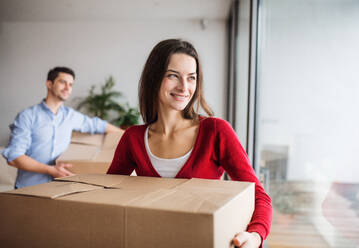 Young happy couple with cardboard boxes moving in a new home. - HPIF31028