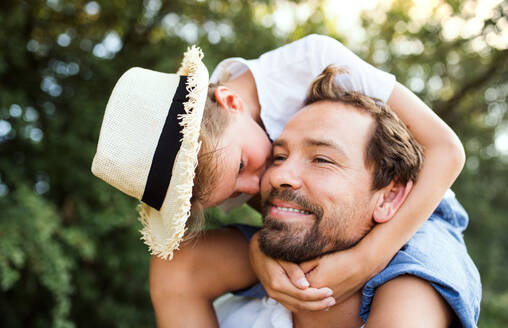 Young father in nature giving a small son a piggyback ride. A close-up. - HPIF31061