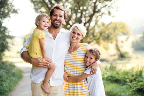 A portrait of happy young family with small children spending time together outside in green summer nature. - HPIF31064