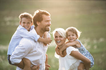 Happy young family with small children spending time together outside in green summer nature at sunset. - HPIF31088