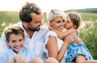 Happy young family with small children spending time together outside in green summer nature at sunset. - HPIF31090