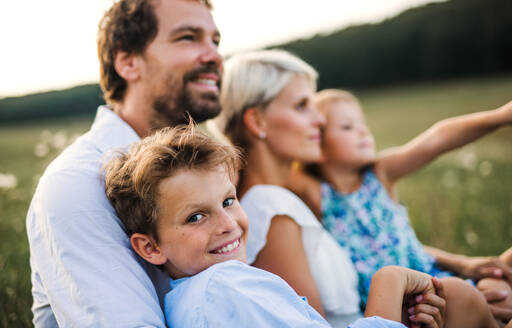 Happy young family with small children spending time together outside in green summer nature at sunset. - HPIF31092