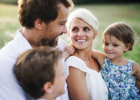 Happy young family with small children spending time together outside in green summer nature at sunset. - HPIF31093