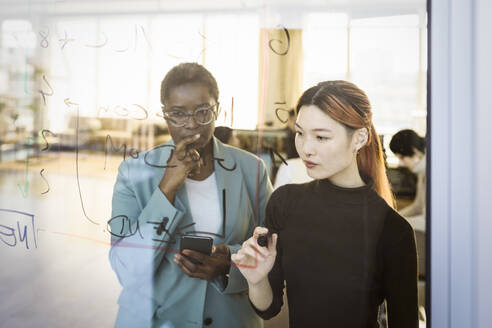 Multiracial female colleagues brainstorming in creative office - MASF36977