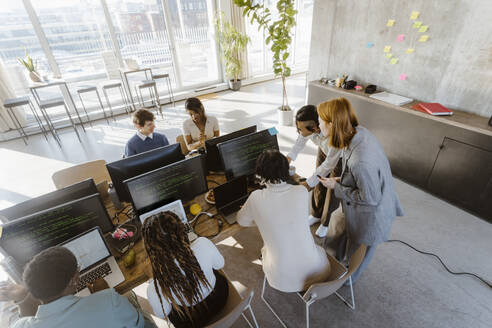 High angle view of programmers working on computers at desk in creative office - MASF37011