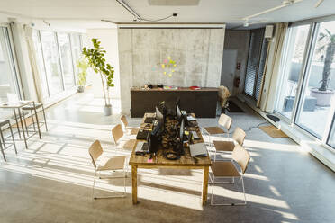 High angle view of computers and laptops on desk in creative office - MASF37014