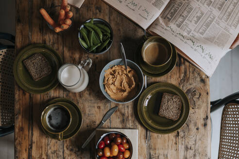 Directly above shot of breakfast arranged on wooden dining table at home - MASF37109