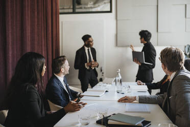 Male and female entrepreneurs attending business meeting in board room at office - MASF37136