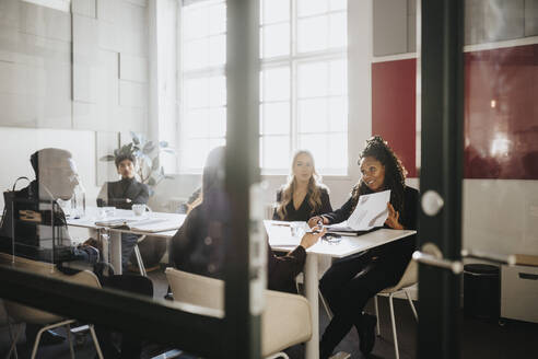 Male and female entrepreneurs planning strategy sitting in board room at office - MASF37159