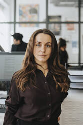 Portrait of female entrepreneur with brown hair at office - MASF37181