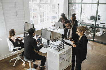 High angle view of corporate colleagues working together at office - MASF37193