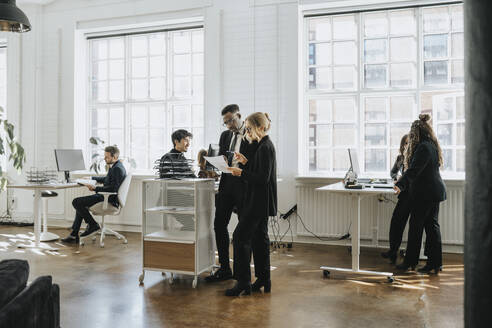 Male and female business colleagues working together at corporate office - MASF37194