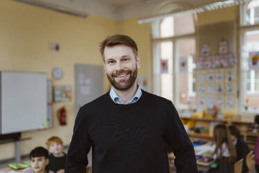 Portrait of smiling mature male teacher in classroom - MASF37218