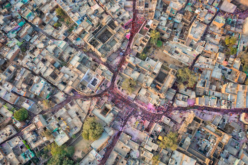 Aerial view of people celebrating the holy colour festival in the street in Barsana, Uttar Pradesh, India. - AAEF18184