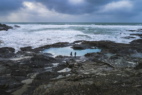 Aerial view of Treyarnon Bay seapool in winter with swimmers about to take a cold water swim, Treyarnon, Cornwall, United Kingdom. - AAEF18191