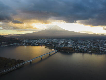 Aerial view of Kawaguchiko bridge in front of Mount Fuji at sunset during koyo season, Lake Kawaguchi, Yamanashi, Japan. - AAEF18229