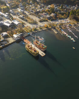 Aerial shot at sunrise of traditional wooden cruise boats on Lake Ashi, Hakone, Kanagawa, Japan. - AAEF18237