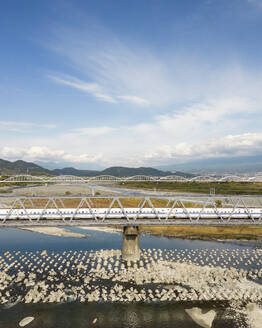 Aerial view of the Tokaido Shinkansen on a bridge over the Fuji-kawa river, Shizuoka, Japan. - AAEF18239