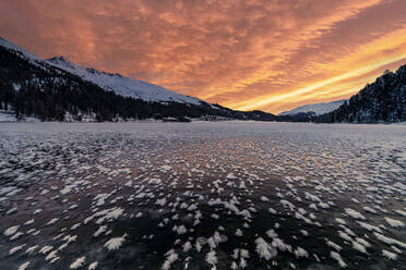 Burning sky at dawn over the frozen Lake Champfer covered with ice flowers in winter, Engadine, Graubunden canton, Switzerland, Europe - RHPLF24178