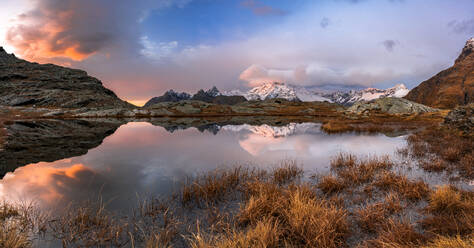 Multicolored sky at dawn over the snowy peak of Monte Disgrazia in autumn, Alpe Fora, Valmalenco, Valtellina, Lombardy, Italy, Europe - RHPLF24190