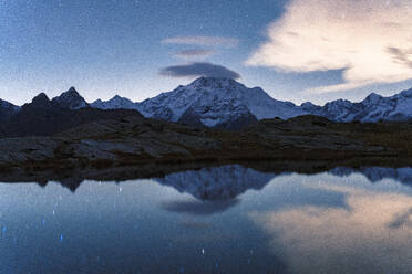 Starry sky over the snowy Monte Disgrazia reflected in water, Alpe Fora, Valmalenco, Valtellina, Sondrio province, Lombardy, Italy, Europe - RHPLF24193