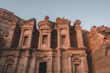 Al Deir (Monastery) facade at sunset with some people on top of it, Petra, UNESCO World Heritage Site, Jordan, Middle East - RHPLF24382