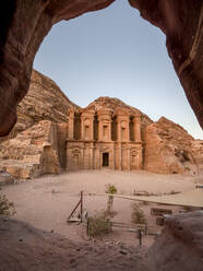 Al Deir (Monastery) monument at sunset, carved into the mountain side and framed by a cave, Petra, UNESCO World Heritage Site, Jordan, Middle East - RHPLF24384