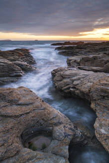 Sunset over the North Atlantic from the rocky Cornish seashore near Padstow, Cornwall, England, United Kingdom, Europe - RHPLF24650