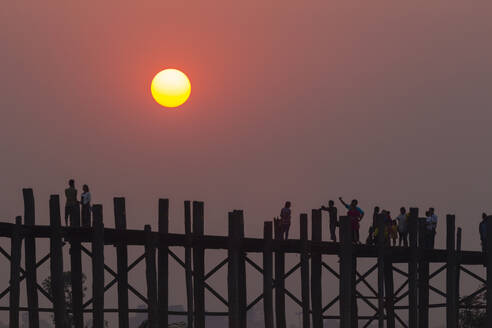 People walking on U-Bein bridge over Taung Tha Man Lake at sunset, Amarapura, Mandalay, Myanmar (Burma), Asia - RHPLF24882