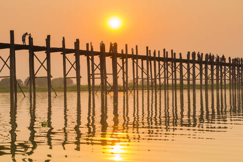 People walking on U-Bein bridge over Taung Tha Man Lake at sunset, Amarapura, Mandalay, Myanmar (Burma), Asia - RHPLF24887