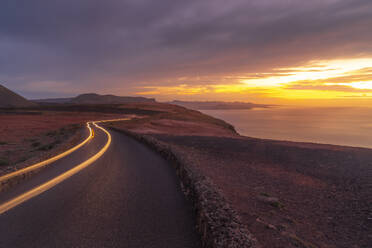 View of trail lights and volcanic coastline from Mirador del Rio at sunset, Lanzarote, Las Palmas, Canary Islands, Spain, Atlantic, Europe - RHPLF25061