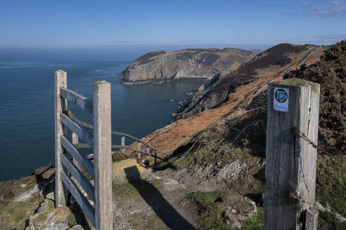 Gate and coast path sign framing Llanlleiana Head on The Anglesey Coastal Path, near Cemaes, Anglesey, North Wales, United Kingdom, Europe - RHPLF25159