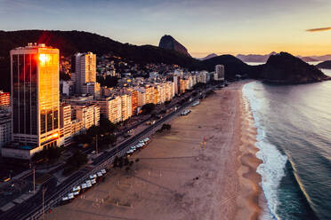 Aerial drone view of Leme Beach in the Copacabana district at sunrise with the iconic Sugarloaf Mountain in the background, UNESCO World Heritage Site, Rio de Janeiro, Brazil, South America - RHPLF25247