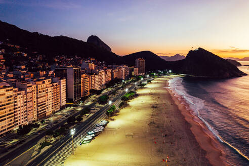 Aerial drone view of Leme Beach in the Copacabana district at sunrise with the iconic Sugarloaf Mountain in the background, UNESCO World Heritage Site, Rio de Janeiro, Brazil, South America - RHPLF25248